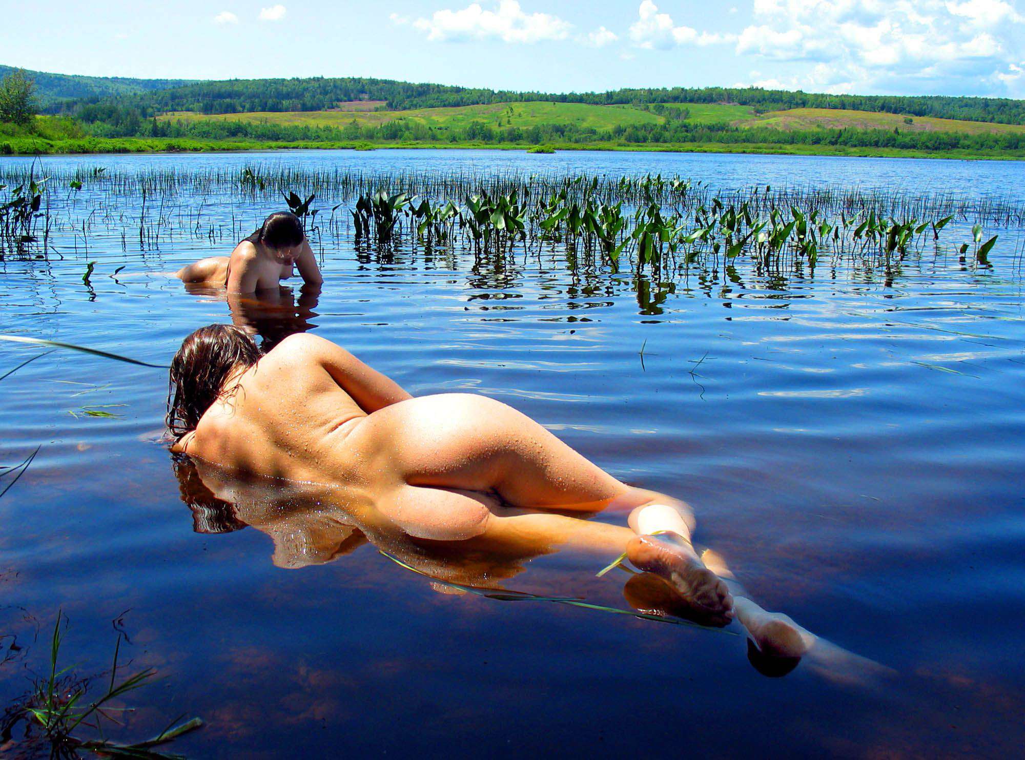 На берегу озера голая девка наслаждается природой