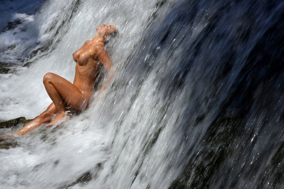 Голенькая милаха светит прелестями возле водопада - порно фото