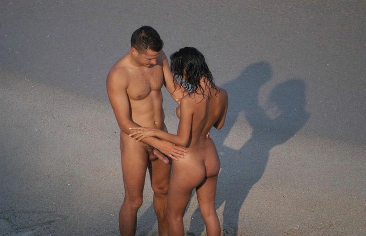 Голые мужчины и женщины на пляже.