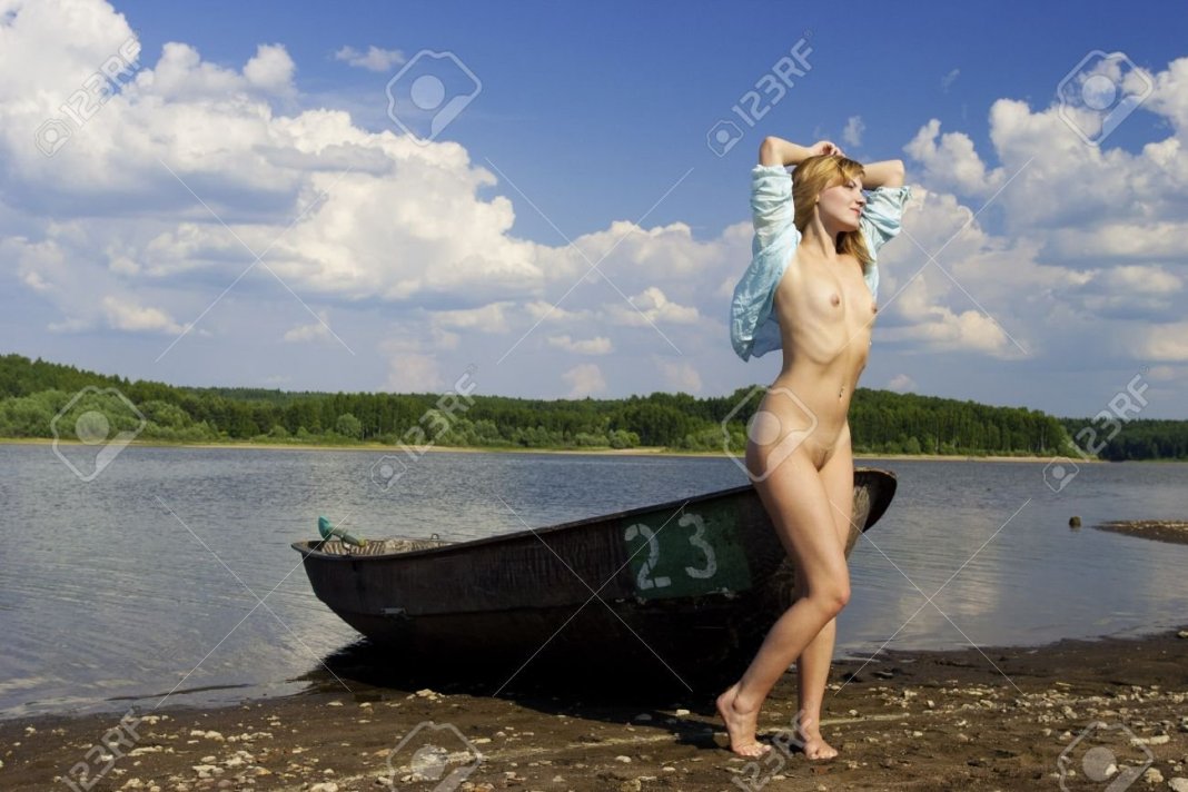 Голая позирует в лодке
